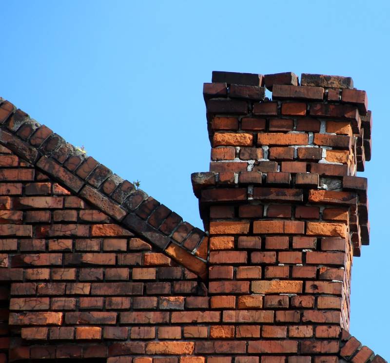 Damaged chimney on an Lewisville home showing cracks and missing mortar
